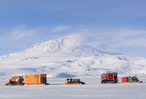 Our vehicle train leaves McMurdo Station under a bright blue sky