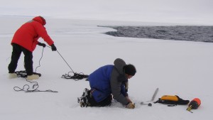 Brian sets up an ice anchor while Jeff Hoffman flakes out a belay rope.  The ice edge is in the background.